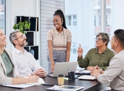 Team members around a table smiling